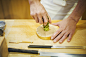 A chef working in a small commercial kitchen, an itamae or master chef grating horseradish root for wasabi.