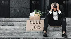 请雇用我吧。沮丧的商人坐在户外的海报需要工作的文字，全景，自由空间