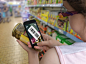 Woman is shopping in supermarket and scanning barcode with smartphone.