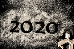 2020年新年快乐。创意拼贴数字2和零组成了2020年。美丽闪亮的金色数字2020和礼物在黑色的背景