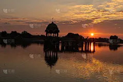 日出时分，拉贾斯坦邦加迪萨加尔(Gadi Sagar)湖上的古代建筑废墟。
