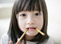 Japanese girl eating pretzels with looking at camera