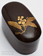 Fine Taisho Period (1912-1926) Japanese lacquer ink box (suzuribako). This oval suzuribako is very unusual in shape and in surface treatment. The surface is painted wood grain with a gold high relief painting of a branch of kumquats. There is a single tra