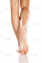漂亮的女性腿和光脚在白色的背景