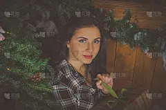 穿着格子衬衫的漂亮女孩站在圣诞树旁