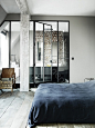 floor to ceiling glass between bedroom and bath. exposed bricks and beams.