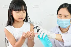 亚洲护士或医生或医疗助理正在为女孩按压一瓶酒精清洁剂，选择性地集中在手上。