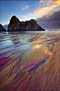 北美洲-紫色沙滩：紫色沙滩也称帕非佛沙滩（Pfeiffer Beach）位于加利福尼亚州的大苏尔，帕非佛沙滩为世界上最浪漫的紫色沙滩，这里是紫色石榴石的家园，千百万年间，由于风浪的不断冲刷，帕非佛海岸上的紫色石榴石矿脉逐渐破碎、剥落。它们落在海中，在海水的带动下反复撞击、研磨，终于形成了一片极为细腻的紫色细沙，这些紫色细沙帕非佛海岸逐渐堆积，方圆足有上万平米，让帕非佛又有了“宝石沙滩”的美誉。