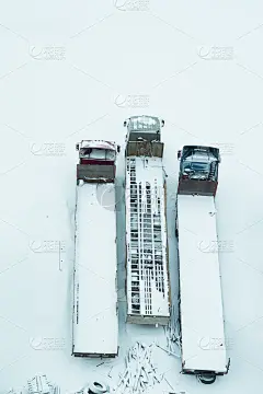 雪下的卡车。一场又一场雪覆盖着卡车。长卡车排成一排鸟瞰图。运输的概念。冰雪覆盖的车辆。本空间