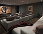 Design ideas for a modern home cinema in Orange County with grey walls, carpet, a wall mounted tv and brown floors.