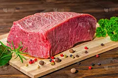 大块生的去骨牛肉配上胡椒，迷迭香，欧芹放在木桌上，特写