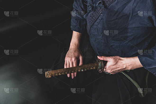 一个坐着的人，一只手握着剑。