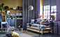 A yellow and purple studio apartment with a practical pine UTÅKER sofa bed which can be used as a sofa, single, double or twin beds. The IVAR storage in wood with cabinet units in grey steel can be seen in the backgrounds.