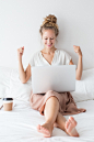 Cheerful Girl Working on Laptop on Bed Free Photo
