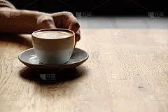 手里拿着一杯咖啡。柔和的灯光
