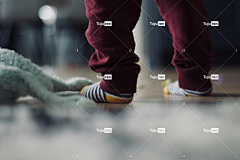 穿着袜子的幼儿站在地板上的娃娃旁边