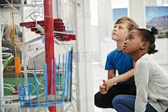 两个孩子跪着看科学展览