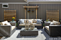 A comfortable outdoor space with a cushioned couch set, wicker table and rustic wood decor.