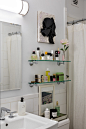 A small bathroom with glass shelves