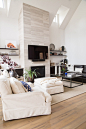 Living room - transitional open concept medium tone wood floor living room idea in Houston with white walls, a stone fireplace, a wall-mounted tv and a standard fireplace