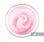 Above view of pink beauty cream in bowl on white background