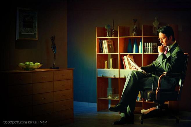 书房里坐在椅子上看书的成功男士