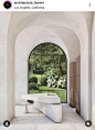 This may contain: an arch in the middle of a room that has a bench and windows on it