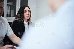 一群商务人士在一个现代化的办公室里，工作的商人策划创意产生和商业计划。商人们正坐在计划会议的桌旁。经