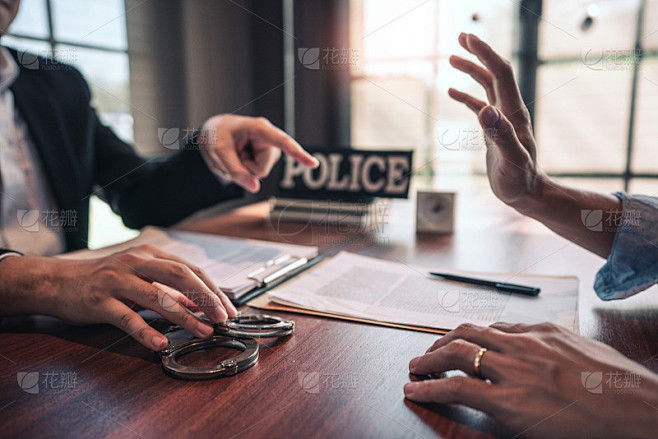 戴手铐的犯罪嫌疑人在审讯室接受警察讯问，刑法概念