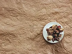 干玫瑰玫瑰在白色杯在棕色纸背景。作者处理，胶片效果。
