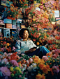 Fifty year old Chinese mother playing skateboarding,smiled, surrounded by flowers, art by Rinko kawauchi, in the style of naturalistic poses, low angle, youthful energy, body extentions, analog film, super detail, dreamy lofi photography, colourful, volum