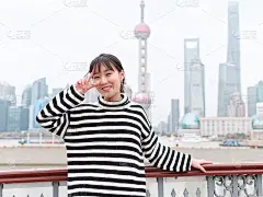 冬日里以上海地标为背景的中国年轻女子的肖像。