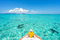 Man sitting on boat sailing through tropical lagoon island paradise