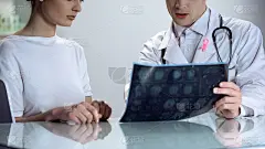 男医生向年轻女士解释乳房x光检查结果，提高对乳腺癌的认识