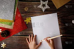 小男孩在给圣诞老人写信。黑色背景与圣诞工艺品和亲爱的圣诞老人短语。
