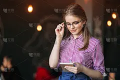 一个漂亮友好的女服务员的肖像，戴着眼镜，用信纸和笔准备为您点菜