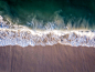 Drone picture of waves hitting the beach.摄影照片