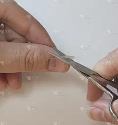 一个人用小剪刀剪指甲。男人的修指甲。一个男人剪下一颗又大又长的钉子