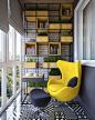 A modern balcony with a bookcase and a stylish armchair