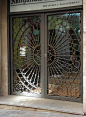 Doors with circle-pattern security bars : Security bars as art, possibly a Chrysanthemum design.