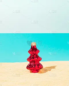 热带海滩上的红色圣诞树。冬季圣诞假日概念。新年快乐背景。最小的夏日海滩想法。
