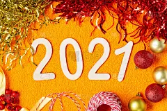 2021年新年快乐。橙色背景的圣诞或新年装饰品。圣诞背景与木制数字2021