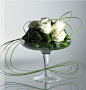 Bear grass, roses and aspidistra leaves elegantly arranged on pedestal dish.: 