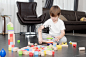 little boy build tower of colorful wooden blocks