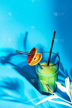 夏季时尚的鸡尾酒。一杯橙汁和可重复使用的铁吸管。明亮，简约的夏日饮品概念。