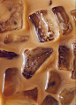 This may contain: ice cubes are melting on top of each other in brown and white liquid, as seen from above