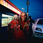 David Lachapelle and Terr Richardson and PrettyPuke photo of a demonic, haggard, old, hideous witch covered in red paint and burger beef smiling outside of a 7 eleven, high flash, eerie, beautiful, wondrous, fairytale, magic, psychedelic, Telecine 2001, F