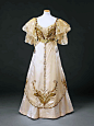 1908-09 丝缎晚礼服，上衣和裙子的蝴蝶是非常新艺术主义风格的造型，线条蜷曲蜿蜒，饰以金色和青色的珠子，珠母圆片，金线，水钻。轻盈层叠的蕾丝袖子上也垂下珠串。 ​​​