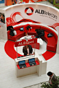 ALBTELECOM - EXHIBITION STAND [cool couch nook and continuation of the space with red flooring -area]