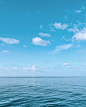 blue body of water under blue and white sky during daytime